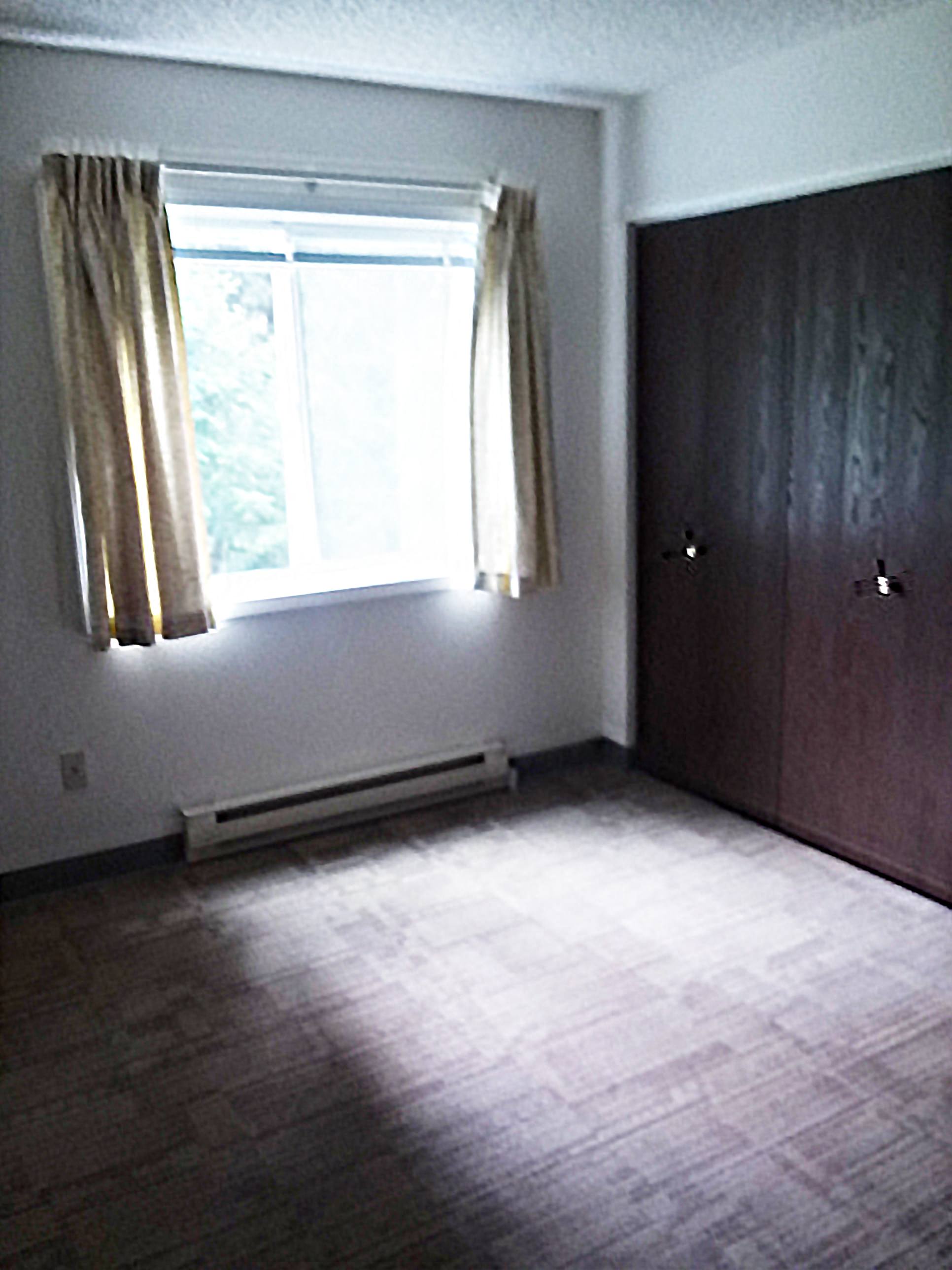 Image of bedroom with closet, base board heater, and window